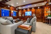Luxurious yacht interior with plush seating, wood paneling, and large TV, CMN Custom 2002 model.