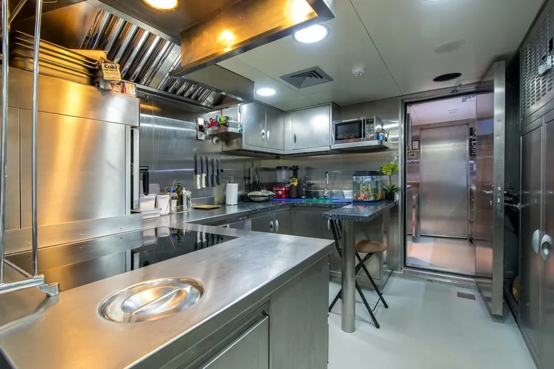  Yacht Photos Pics Modern stainless steel kitchen with appliances, featuring a fish tank and sleek design.