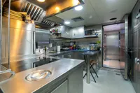 Modern stainless steel kitchen with appliances, featuring a fish tank and sleek design.