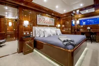 Luxurious yacht bedroom with elegant wood paneling, plush bedding, and ambient lighting, CMN Custom 2002.