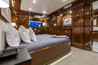 Luxurious yacht bedroom with elegant wood paneling, modern lighting, and stylish decor, CMN Custom 2002.