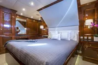 Luxurious yacht bedroom with elegant wood paneling, soft lighting, and plush bedding, CMN Custom 2002.