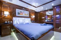 Luxurious yacht bedroom with wood paneling, modern lighting, and elegant bedding, CMN Custom 2002.
