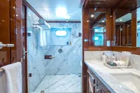Luxurious yacht bathroom with marble shower, wooden accents, and elegant fixtures, CMN Custom 2002.