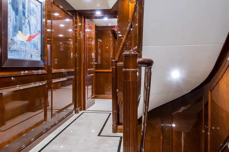  Yacht Photos Pics Luxurious wooden interior of a 2002 CMN Custom yacht with elegant staircase and artwork.