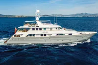 Luxurious 2002 CMN Custom yacht cruising on open sea with scenic coastline backdrop.