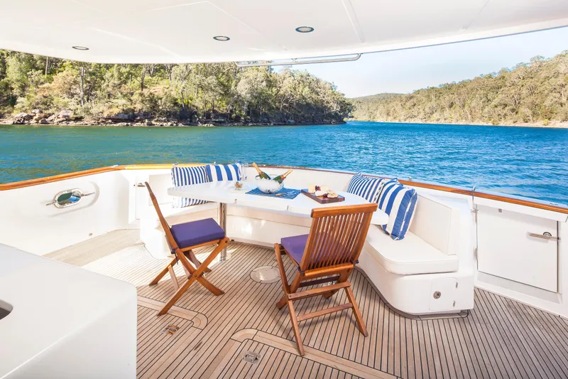  Yacht Photos Pics Luxurious 2013 Nordhavn 68 yacht deck with seating, overlooking serene blue waters and lush greenery.