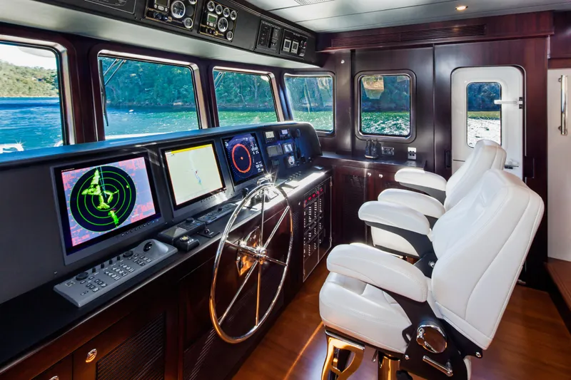  Yacht Photos Pics Pilothouse of 2013 Nordhavn 68 yacht with navigation screens and white captain chairs.