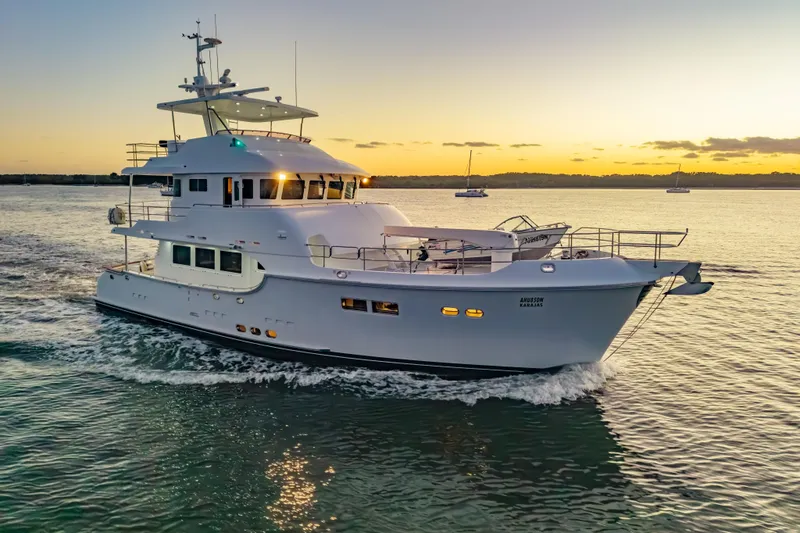 Yacht Photos Pics Luxurious 2013 Nordhavn 68 yacht cruising at sunset on tranquil waters.