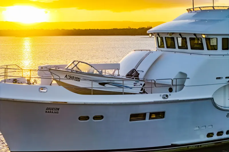  Yacht Photos Pics 2013 Nordhavn 68 yacht at sunset, featuring sleek design and tender boat on deck.