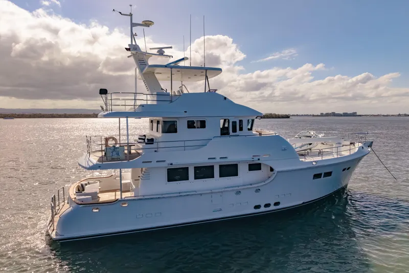  Yacht Photos Pics Luxurious 2013 Nordhavn 68 yacht cruising on serene waters under a partly cloudy sky.