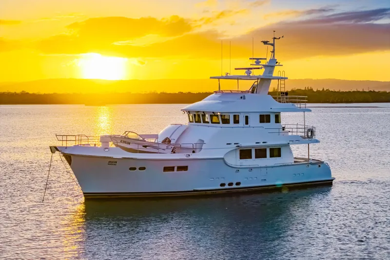  Yacht Photos Pics Luxurious 2013 Nordhavn 68 yacht at sunset on tranquil waters.