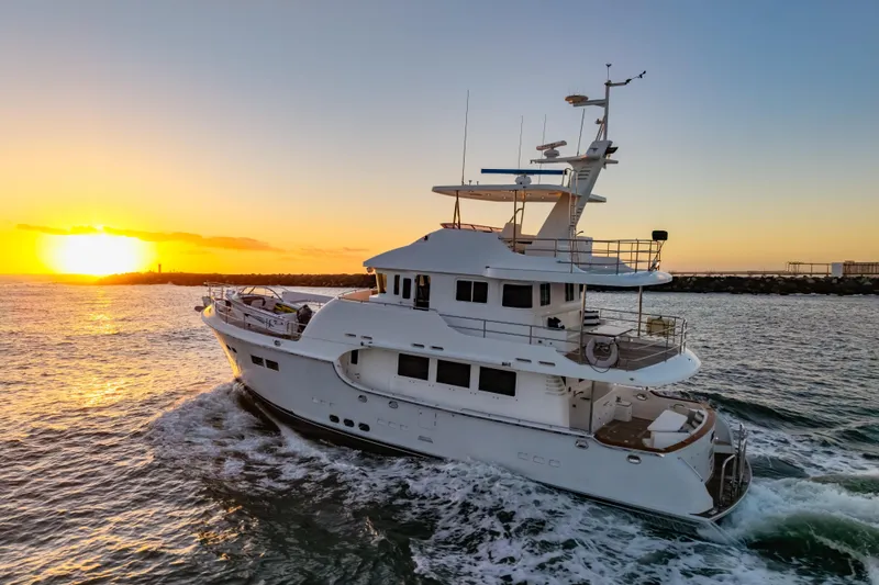  Yacht Photos Pics Nordhavn 68 yacht cruising at sunset, 2013 model, on open water.