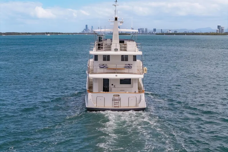  Yacht Photos Pics Nordhavn 68 yacht cruising on open water, city skyline in background, 2013 model.