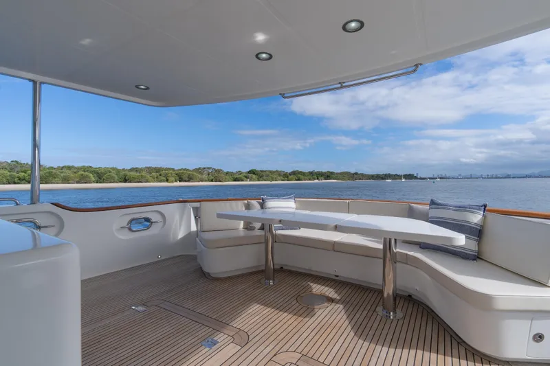  Yacht Photos Pics Luxurious 2013 Nordhavn 68 yacht deck with seating, overlooking serene waters and lush shoreline.