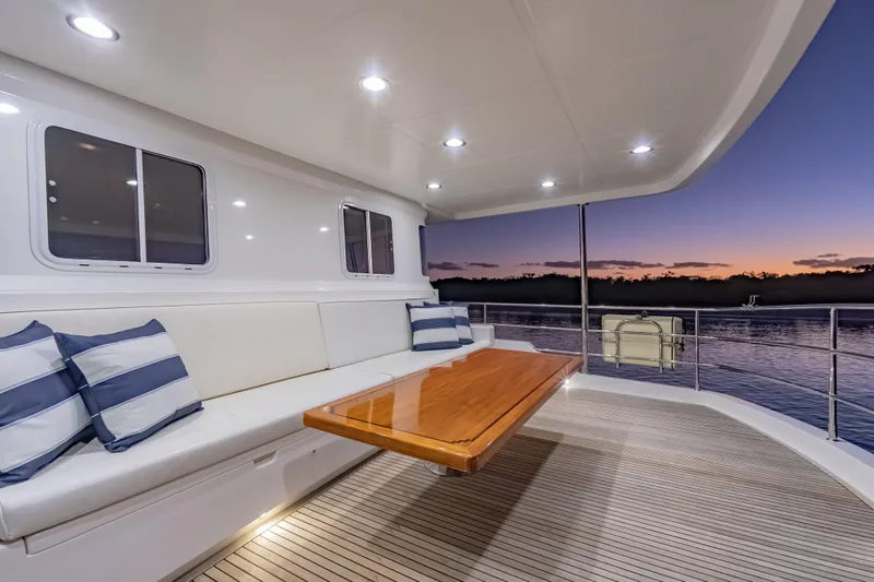  Yacht Photos Pics Luxurious 2013 Nordhavn 68 yacht deck at sunset with elegant seating and table.