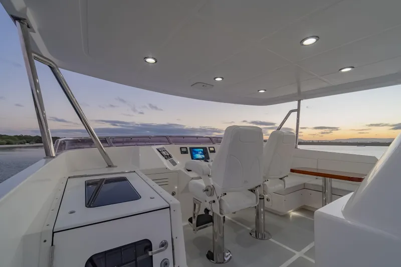  Yacht Photos Pics Luxurious 2013 Nordhavn 68 yacht helm with modern seating and sunset view.