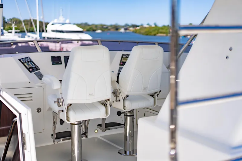  Yacht Photos Pics Luxury helm station on 2013 Nordhavn 68 yacht with white captain chairs.