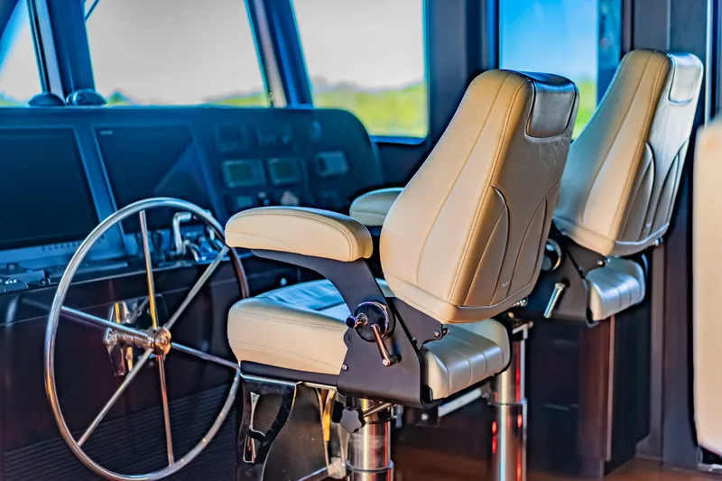  Yacht Photos Pics Pilothouse of 2013 Nordhavn 68 yacht with leather captain chairs and steering wheel.