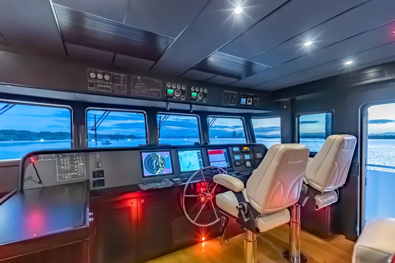  Yacht Photos Pics Pilothouse of 2013 Nordhavn 68 yacht with navigation equipment and panoramic windows at sunset.