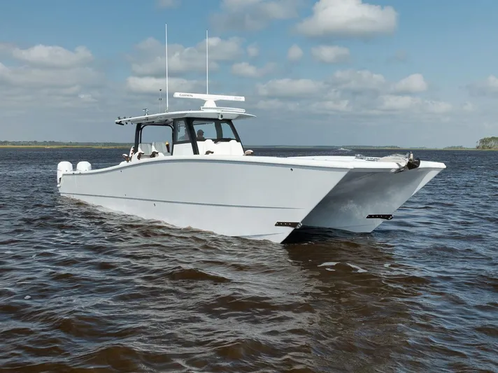  Yacht Photos Pics Freeman 47 boat, 2023 model, cruising on open water under a partly cloudy sky.