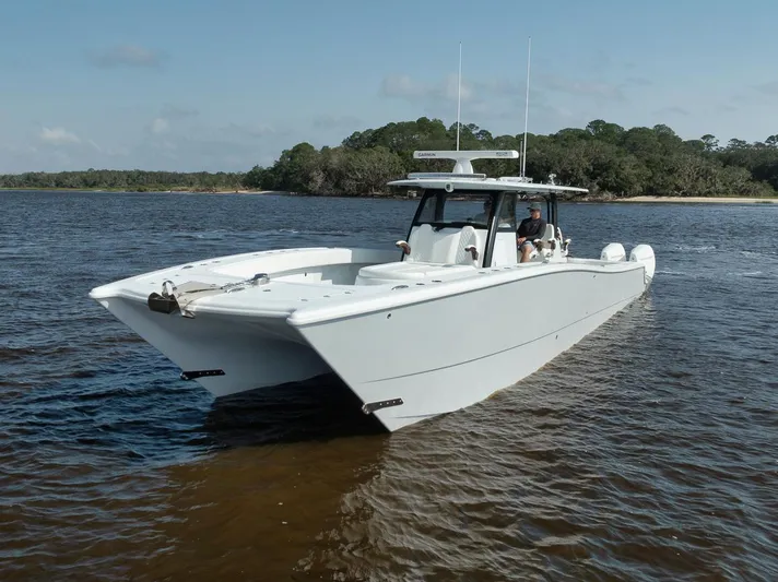  Yacht Photos Pics 2023 Freeman 47 boat cruising on a calm river near a forested shoreline.