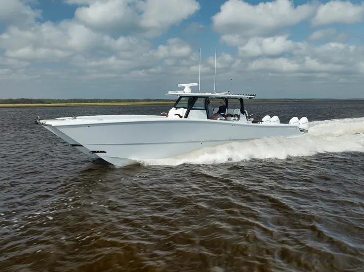  Yacht Photos Pics 2023 Freeman 47 boat cruising on open water under cloudy skies.