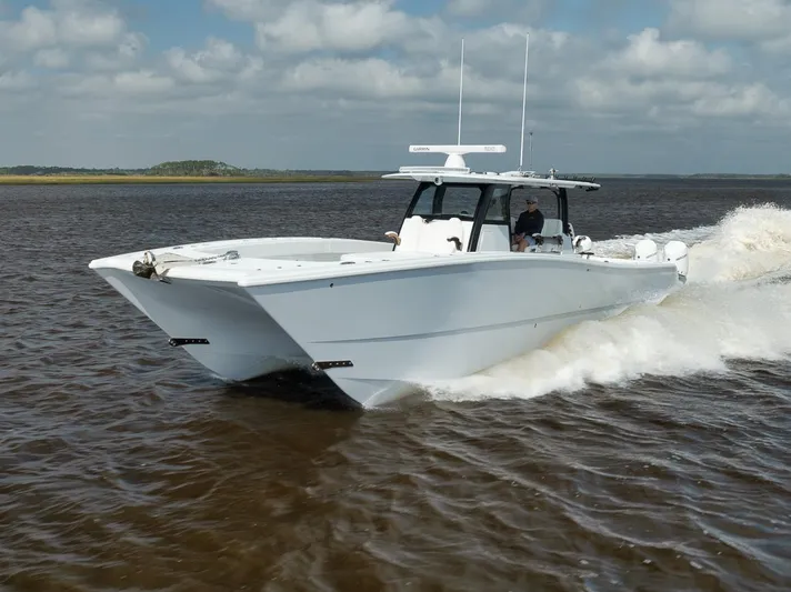  Yacht Photos Pics 2023 Freeman 47 boat cruising on open water under cloudy skies.
