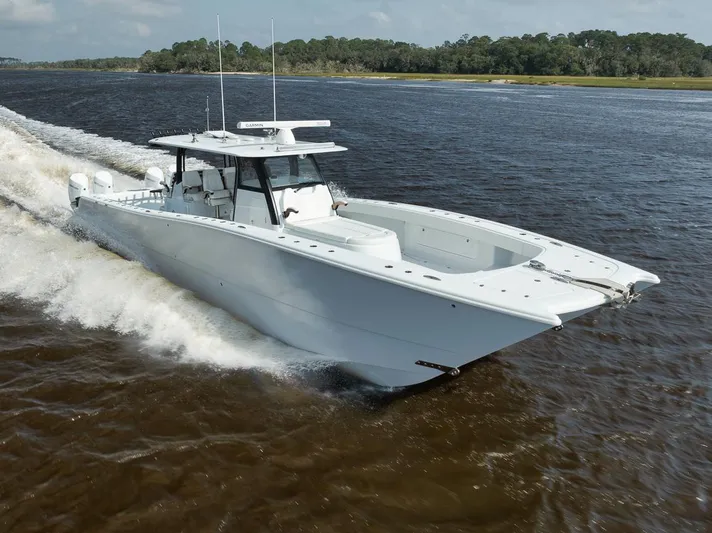  Yacht Photos Pics Freeman 47 boat cruising on a river, 2023 model, surrounded by lush greenery.