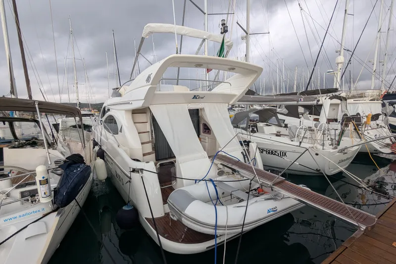  Yacht Photos Pics Azimut 46 yacht from 2000 docked at a marina, surrounded by other boats.