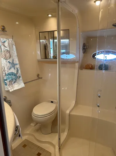 Yacht Photos Pics 2001 Sea Ray 560 Sedan Bridge bathroom with shower, toilet, and nautical-themed towel.