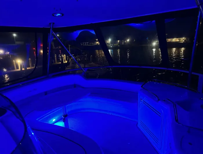  Yacht Photos Pics Interior of 2001 Sea Ray 560 Sedan Bridge yacht illuminated with blue lights at night.