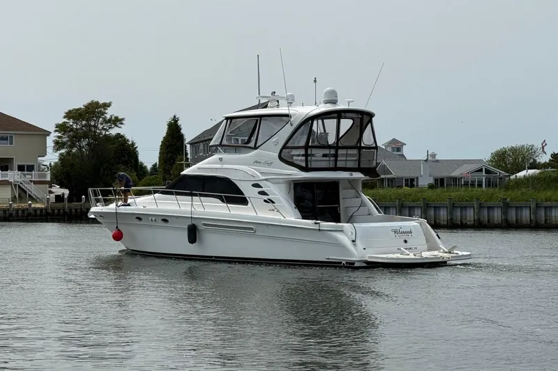  Yacht Photos Pics 2001 Sea Ray 560 Sedan Bridge yacht cruising near waterfront homes.