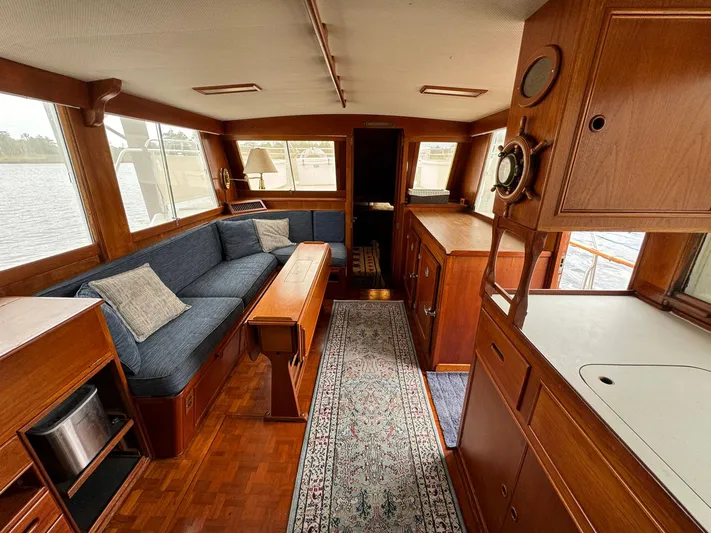 Carolina Breeze Yacht Photos Pics Interior of 1989 Grand Banks 42 Motor Yacht with wooden furnishings and blue seating.