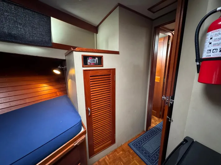 Carolina Breeze Yacht Photos Pics Interior of 1989 Grand Banks 42 Motor Yacht with wooden cabinetry and blue bedding.