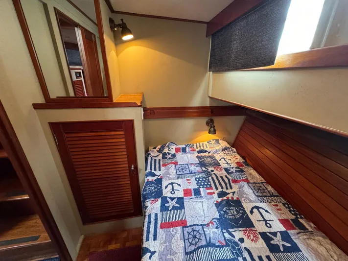 Carolina Breeze Yacht Photos Pics Cozy cabin interior of 1989 Grand Banks 42 Motor Yacht with nautical-themed bedding.