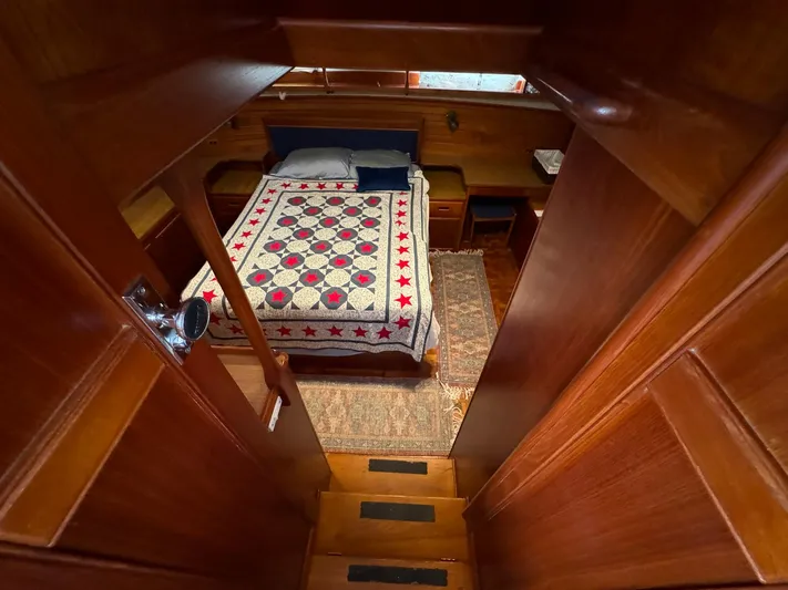 Carolina Breeze Yacht Photos Pics 1989 Grand Banks 42 Motor Yacht cabin with quilted bedspread and wooden interior.