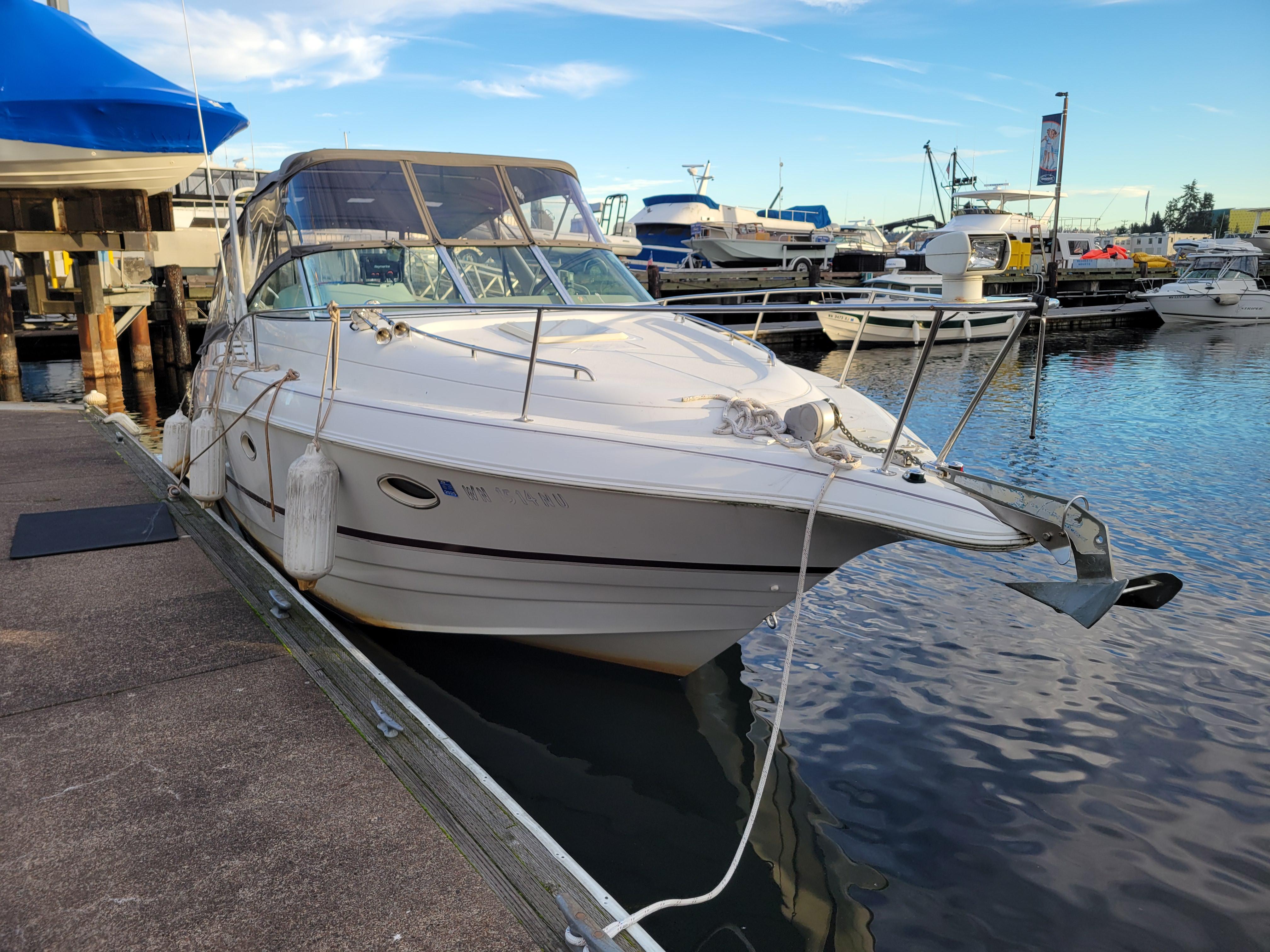 1997 Larson 290 Cabrio boat docked at marina under clear sky.