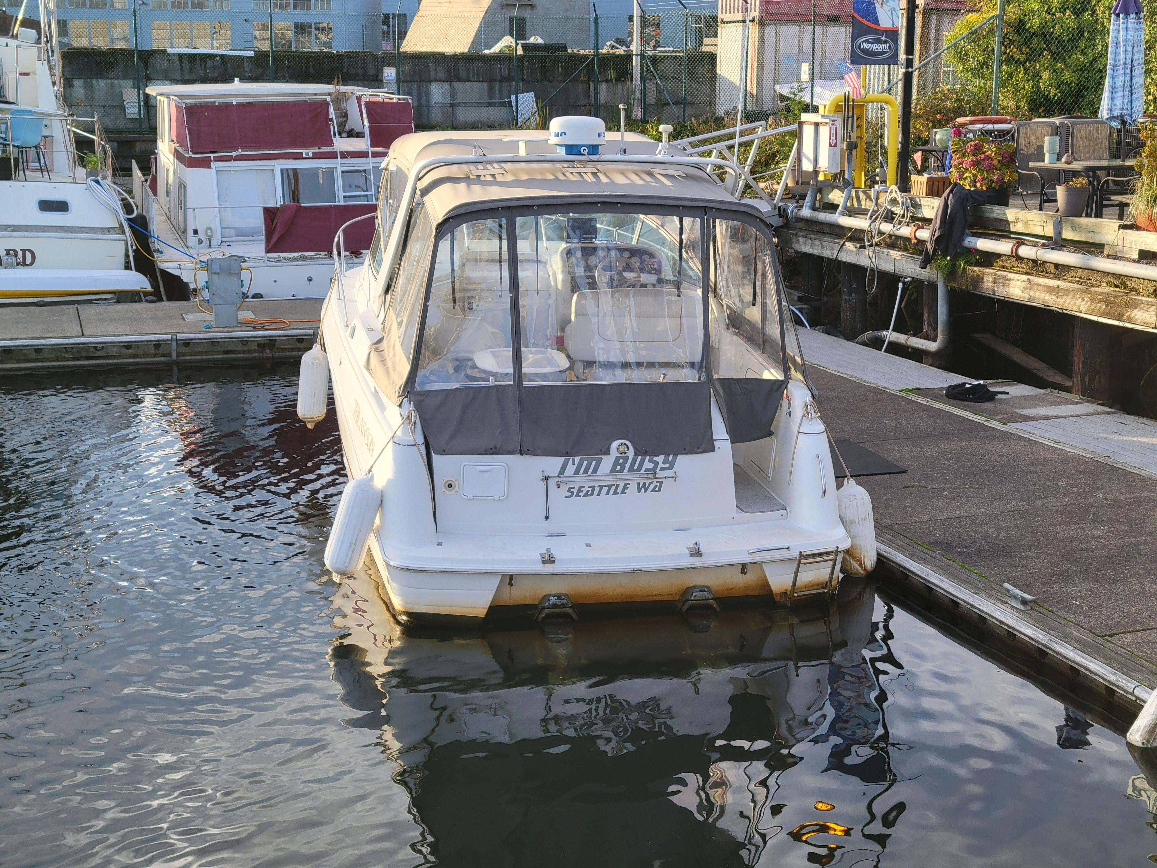 1997 Larson 290 Cabrio boat docked in marina, rear view.