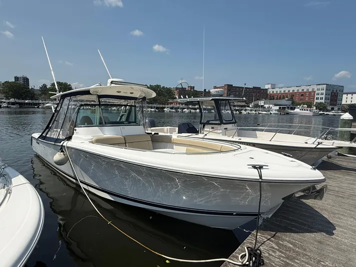 Savages Yacht Photos Pics 2015 Pursuit ST 310 Sport boat docked at marina under clear sky.