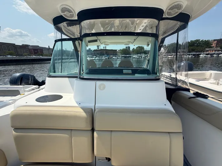 Savages Yacht Photos Pics 2015 Pursuit ST 310 Sport boat with beige seating, docked at a marina.