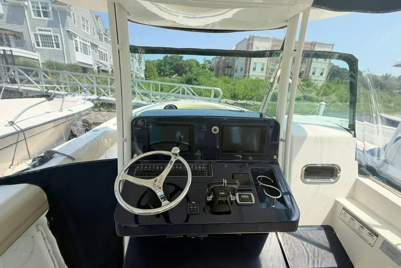 Savages Yacht Photos Pics 2015 Pursuit ST 310 Sport boat helm with steering wheel and navigation controls.