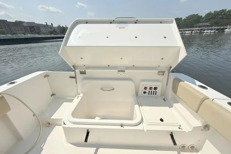 Savages Yacht Photos Pics 2015 Pursuit ST 310 Sport boat with open storage compartment by the water.