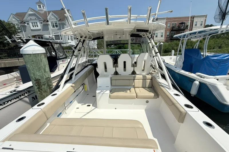 Savages Yacht Photos Pics 2015 Pursuit ST 310 Sport boat with spacious seating, docked near waterfront homes.