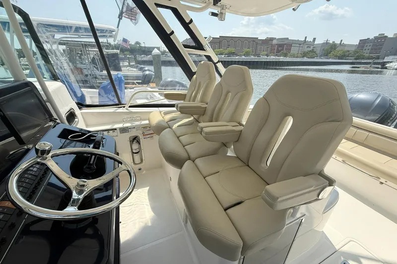 Savages Yacht Photos Pics Interior of 2015 Pursuit ST 310 Sport boat with beige seats and steering wheel.