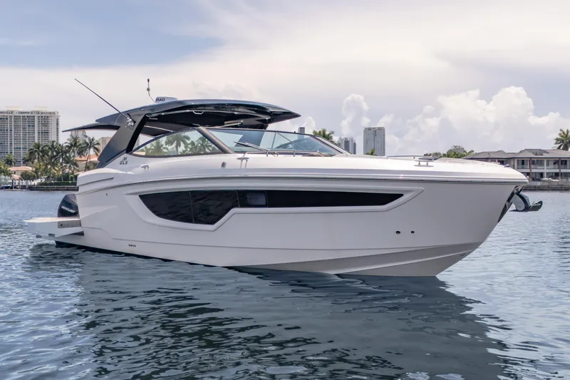  Yacht Photos Pics 2021 Cruisers Yachts 38 GLS luxury boat on calm water, cityscape background.