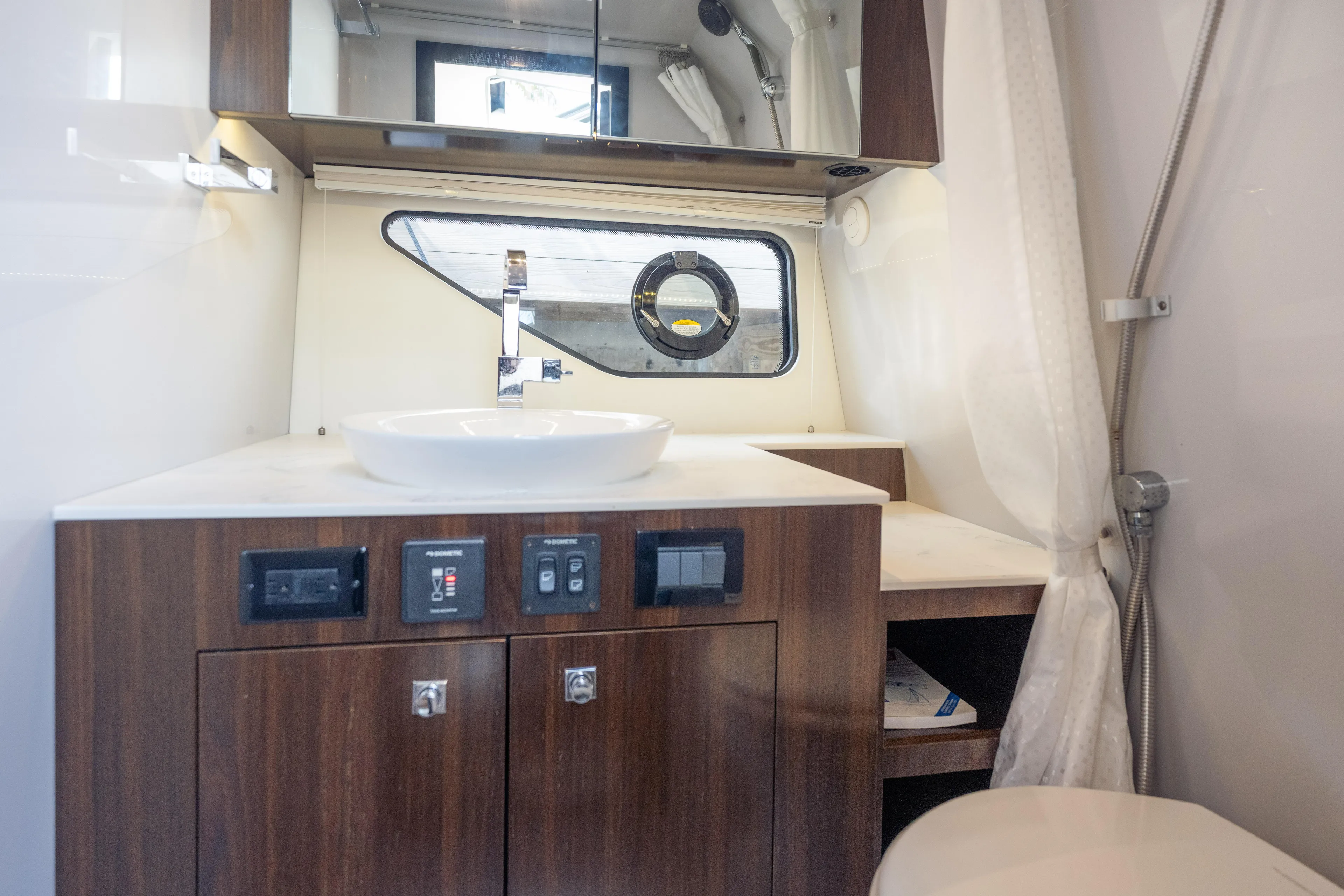  Yacht Photos Pics 2021 Cruisers Yachts 38 GLS bathroom with modern sink and wood cabinetry.