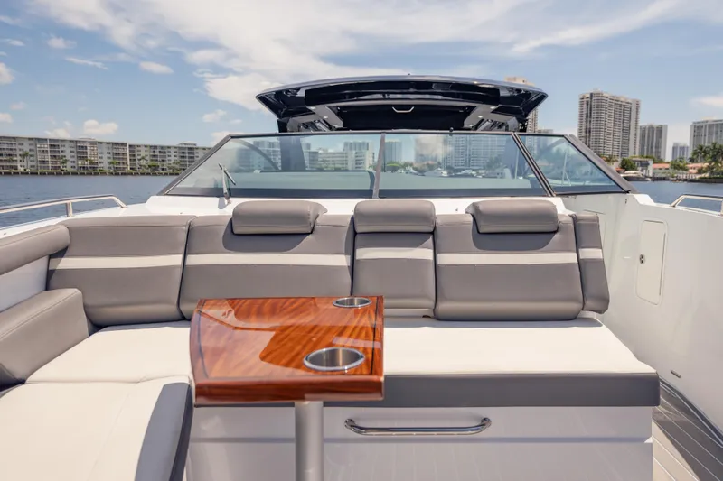  Yacht Photos Pics 2021 Cruisers Yachts 38 GLS luxury boat interior with seating and table, cityscape in background.