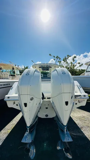  Yacht Photos Pics 2023 Boston Whaler 330 Outrage boat with dual engines under a bright sunlit sky.