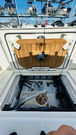  Yacht Photos Pics 2023 Boston Whaler 330 Outrage storage compartment with open hatch, showcasing interior equipment.